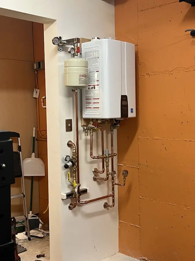 Plumbing technician inspecting water heater connections in Fitzgerald